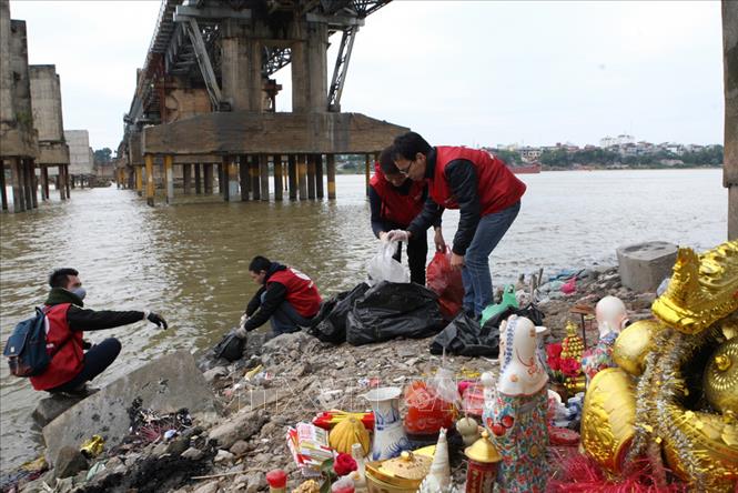 Trong ảnh: Sinh viên tình nguyện Hà Nội thu dọn rác thải do người dân thả xuống sông Hồng trong ngày Tết ông Công, ông Táo. Ảnh: Tuấn Anh – TTXVN