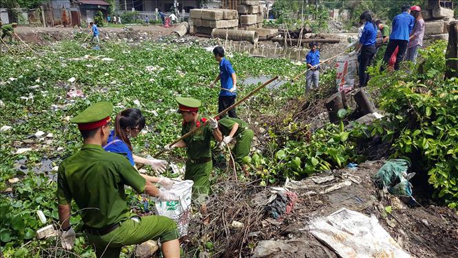 Trong ảnh: Thanh niên tình nguyện thành phố Rạch Giá (Kiên Giang) tham gia vệ sinh trên kênh Vàm Trư, sau lễ ra quân Chiến dịch tình nguyện Hè 2016. Ảnh: Lê Sen - TTXVN