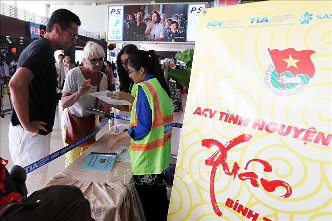 Trong ảnh: Đoàn viên thanh niên tình nguyện TP Hồ Chí Minh tham gia hướng dẫn, hỗ trợ hành khách đi máy bay tại Cảng hàng không Quốc tế Tân Sơn Nhất trong dịp Tết Bính Thân năm 2016. Ảnh: Mạnh Linh - TTXVN