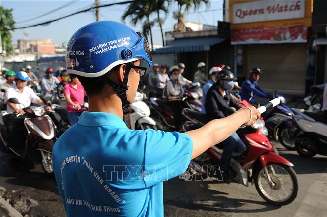 Trong ảnh: Sáng 7/12/2015, hơn 800 tình nguyện viên thuộc 72 Đội hình thanh niên “Phản ứng nhanh” đảm bảo an toàn giao thông đã đồng loạt ra quân tại các giao lộ, tuyến đường trọng điểm 24 quận, huyện trên địa bàn Thành phố Hồ Chí Minh. Ảnh: An Hiếu - TTXVN