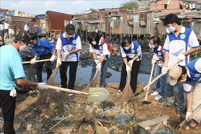 Trong ảnh: Sinh viên Trường Đại học Sài Gòn tham gia thu dọn vệ sinh rạch Ụ Cây. Ảnh: Tràng Dương-TTXVN