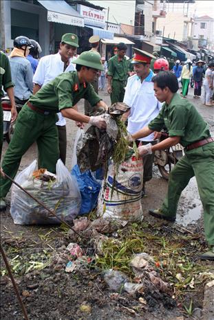 Trong ảnh: Đoàn viên, thanh niên tình nguyện tham gia làm vệ sinh môi trường tại chợ Đồng Xoài (Bình Phước). Ảnh: Hoàng Tuấn-TTXVN