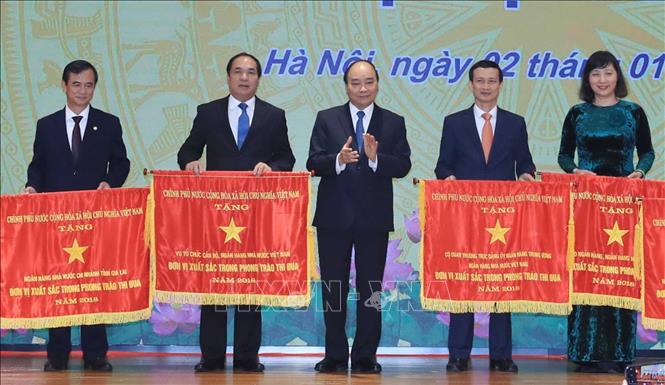 Trong ảnh: Thủ tướng Nguyễn Xuân Phúc tặng Cờ thi đua của Chính phủ cho các tập thể. Ảnh: Thống Nhất – TTXVN