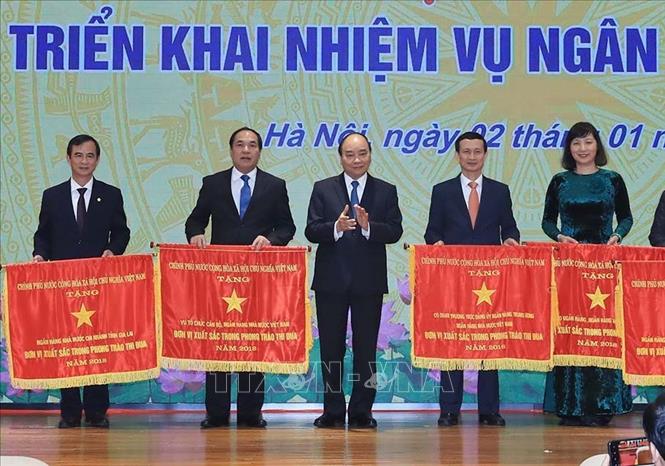 Trong ảnh: Thủ tướng Nguyễn Xuân Phúc trao tặng Cờ thi đua của Chính phủ cho các tập thể. Ảnh: Thống Nhất – TTXVN
