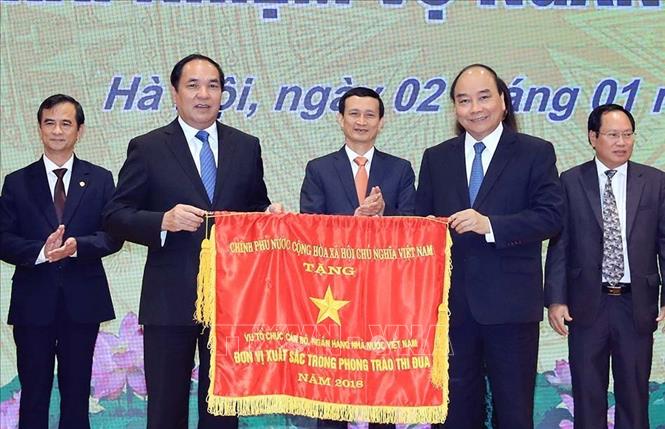 Trong ảnh: Thủ tướng Nguyễn Xuân Phúc trao tặng Cờ thi đua của Chính phủ cho các tập thể. Ảnh: Thống Nhất – TTXVN