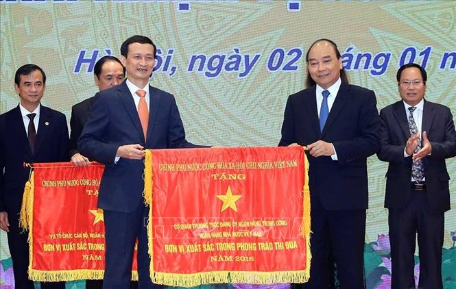 Trong ảnh: Thủ tướng Nguyễn Xuân Phúc trao tặng Cờ thi đua của Chính phủ cho các tập thể. Ảnh: Thống Nhất – TTXVN