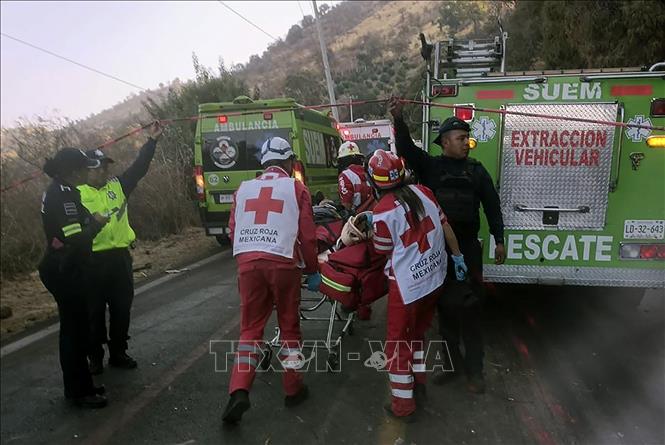 Lực lượng cứu hộ chuyển người bị thương tại hiện trường vụ lật xe buýt ở khu vực Malinalco, bang Mexico, miền Trung Mexico ngày 28/4/2024. Ảnh: AFP/TTXVN