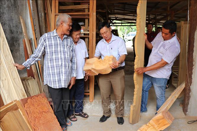 Cán bộ Trung tâm Khuyến công và Xúc tiến thương mại Trà Vinh kiểm tra sản phẩm làm ra từ máy tiện gỗ CNC tại hộ kinh doanh Thạch Phan - Phanh, thị trấn Cầu Kè, huyện Cầu Kè. Ảnh: Thanh Hòa- TTXVN