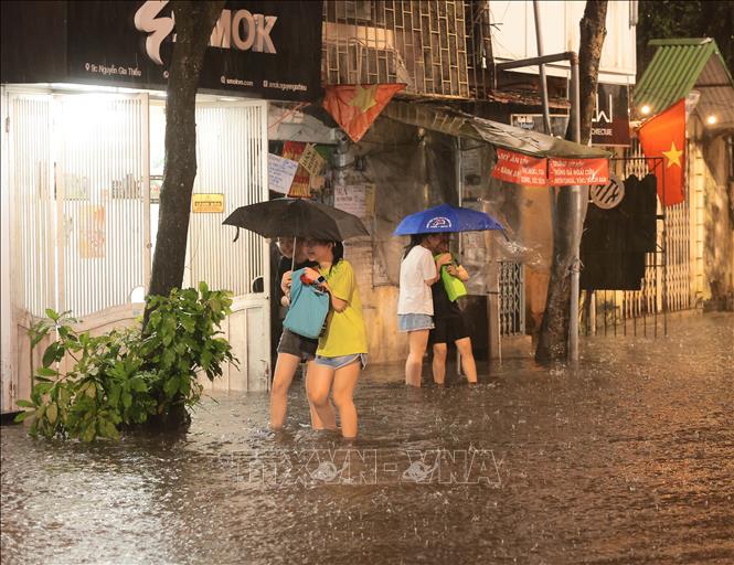 Việc di chuyển của người dân sống trên phố Nguyễn Gia Thiều, quận Hoàn Kiếm bị ảnh hưởng lớn do ngập. Ảnh: Hoàng Hiếu - TTXVN
