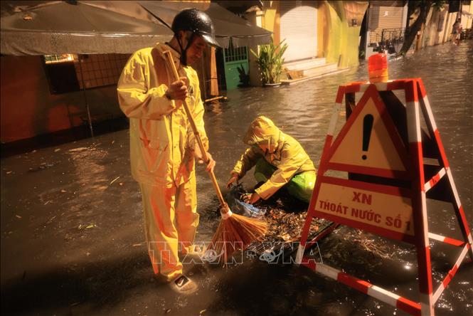 Công nhân xí nghiệp thoát nước số 1 Hà Nội tích cực khơi thông dòng chảy đoạn ngập trên phố Nguyễn Gia Thiều. Ảnh: Hoàng Hiếu - TTXVN