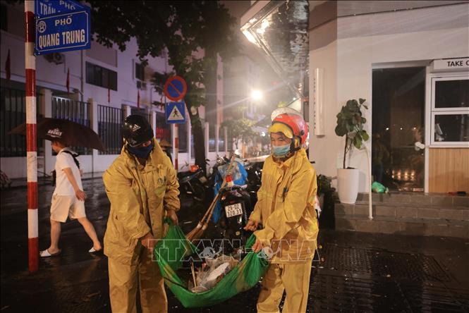 Công nhân xí nghiệp thoát nước Hà Nội tích cực khơi thông dòng chảy đoạn ngập trên phố Trần Quốc Toản. Ảnh: Hoàng Hiếu - TTXVN