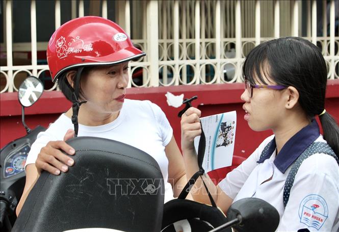 [25/06/2018 18:10:46] Trong ảnh: Phụ huynh sốt ruột hỏi thăm con sau khi kết thúc phần thi môn Toán tại Hội đồng thi trường THCS Collette (Quận 3). Ảnh: Quang Nhựt - TTXVN