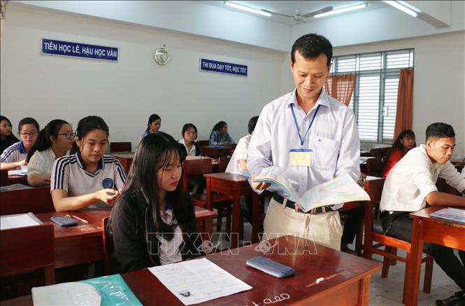 Trong ảnh: Giám thị kiểm tra các tài liệu thí sinh được phép mang vào phòng thi tại điểm thi Trường Trung học phổ thông Long Xuyên, thành phố Long Xuyên, tỉnh An Giang. Ảnh: Công Mạo - TTXVN