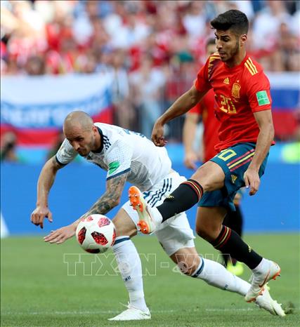 Trong ảnh: Cầu thủ Marco Asensio (phải) của Tây Ban Nha trong pha tranh bóng với tuyển thủ Nga trong trận đấu vòng 1/8 World Cup 2018 diễn ra trên sân Luzhniki ở Moskva ngày 1/7. Ảnh: THX/TTXVN