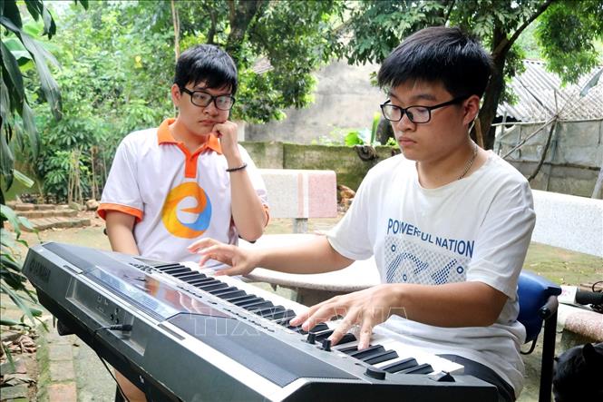 Trong ảnh: Những lúc rảnh rỗi, em Hoàng Đức Thuận thường chơi đàn organ. Ảnh: Trung Kiên - TTXVN.