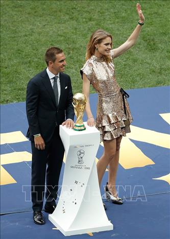 Trong ảnh: Cựu đội trưởng tuyển Đức vô địch World Cup 2014, Philipp Lahm (trái) tiến ra từ đường hầm sân Luzhniki cùng siêu mẫu Natalia Vodianova (phải), và mang theo chiếc cup vàng. Cả hai bước ra gần vòng tròn giữa sân và giương cao chiếc cup vàng tại lễ bế mạc World Cup 2018 ở sân vận động Luzhniki, thủ đô Moscow, Nga tối 15/7. Ảnh: AFP/TTXVN