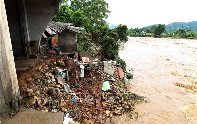 Trong ảnh: Nước lũ dâng cao gây sạt lở, cuốn trôn nhiều ngôi nhà của người dân. Ảnh: Quốc Khánh - TTXVN
