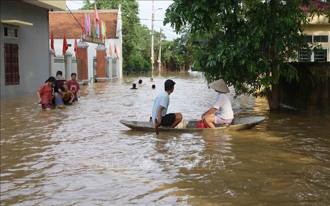 Trong ảnh: Người dân Bùi Xá di chuyển bằng thuyền trên các tuyến đường bị ngập nước. Ảnh: Thanh Tùng-TTXVN