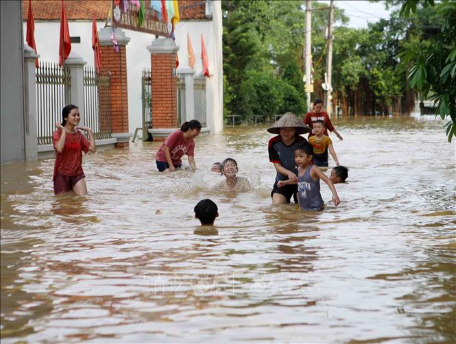 Trong ảnh: Nhiều em nhỏ thích thú bơi lội trên các tuyến đường bị ngập. Ảnh: Thanh Tùng-TTXVN