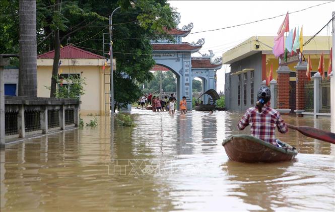 Trong ảnh: Các tuyến đường ở Bùi Xá bị chìm trong nước, người dân phải dùng thuyền để di chuyển. Ảnh: Thanh Tùng-TTXVN
