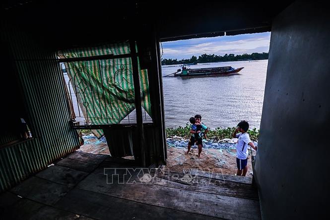 Trong ảnh: Những đứa trẻ ở xã Mỹ Hội Đông, huyện Chợ Mới, tỉnh An Giang vẫn hằng ngày vui chơi tại khu vực 14 căn nhà bị sạt lở xuống sông Hậu một năm trước, mặc cho những cảnh báo đây là khu vực sạt lở nguy hiểm. Ảnh: Trọng Đạt - TTXVN