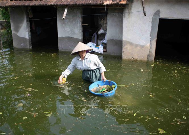 Trong ảnh: Người dân đối mặt với nguy cơ dịch bệnh do rác thải trôi vào nhà. Ảnh: Thanh Tùng - TTXVN