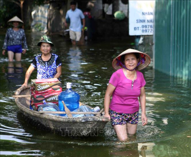 Trong ảnh: Người dân dùng thuyền vận chuyển lương thực và nước uống. Ảnh: Thanh Tùng - TTXVN