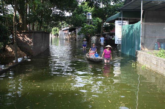 Trong ảnh: Nhiều tuyến đường thuộc xã Tân Tiến, huyện Chương Mỹ ngập sâu gây khó khăn cho người dân. Ảnh: Thanh Tùng - TTXVN