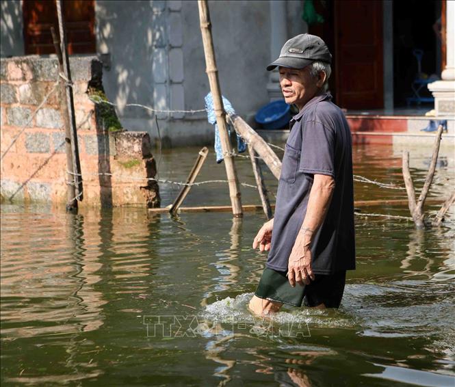 Trong ảnh: Người dân xã Tân Tiến, huyện Chương Mỹ đi lại khó khăn do nước ngập sâu. Ảnh: Thanh Tùng-TTXVN