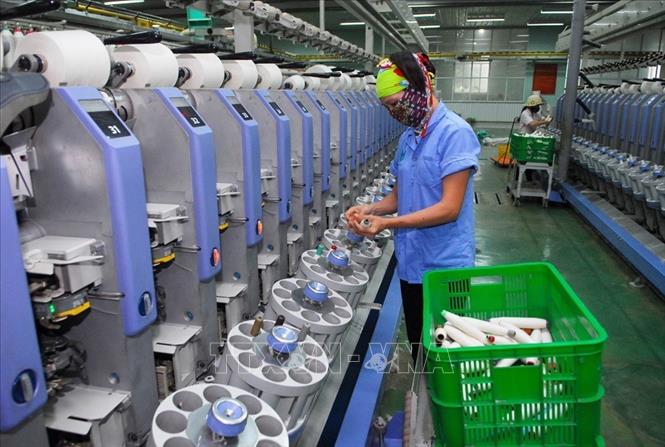 Sản xuất sợi xuất khẩu tại Công ty Cổ phần Đồng Phát, khu công nghiệp Thạch Thất, huyện Quốc Oai (Hà Nội). Sau 10 năm hợp nhất, huyện Thạch Thất tăng trưởng kinh tế trung bình 12%, cơ cấu kinh tế chuyển dịch tích cực, tỷ lệ hộ nghèo từ 9,3% năm 2008 đến nay chỉ còn 1,18%. Ảnh: Danh Lam – TTXVN


