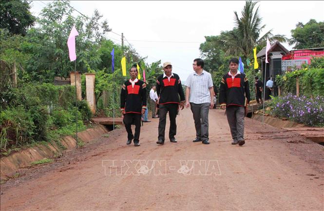 Trong ảnh: Người dân buôn KroA, xã Ea Drơng, huyện Cư M’gar phấn khởi vì được Công ty cà phê 15 đầu tư con đường nhựa khang trang. Ảnh: Phạm Cường-TTXVN