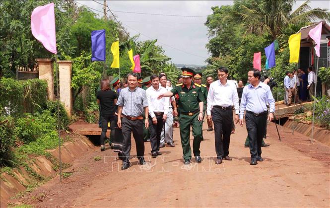 Trong ảnh: Lãnh đạo Công ty cà phê 15 kiểm tra chất lượng con đường nhựa buôn KroA trước khi bàn giao cho địa phương. Ảnh: Phạm Cường-TTXVN