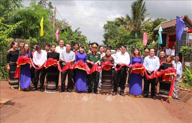 Trong ảnh: Công ty Trách nhiệm hữu hạn Một thành viên cà phê 15 (Quân khu V) cắt băng khánh thành bàn giao con đường nhựa dài 5 km trên địa bàn buôn KroA. Ảnh: Phạm Cường-TTXVN