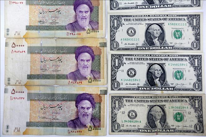 Trong ảnh: Đồng rial của Iran (trái) và đồng USD (phải). AFP/TTXVN