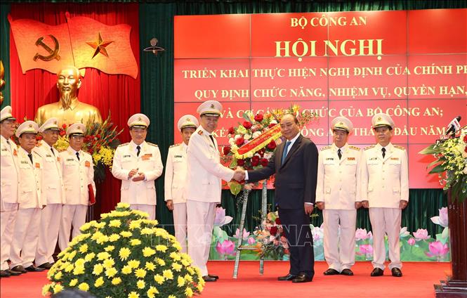 Trong ảnh: Thủ tướng Nguyễn Xuân Phúc tặng hoa chúc mừng lãnh đạo Bộ Công an sau khi công bố Nghị định số 01/2018/NĐ-CP ngày 6/8/2018 của Chính phủ quy định chức năng, nhiệm vụ, quyền hạn và cơ cấu tổ chức của Bộ Công an. Ảnh: Doãn Tấn  – TTXVN