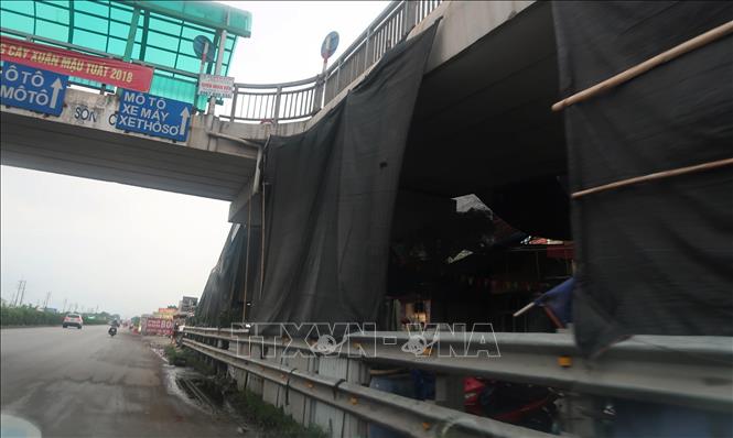 Trong ảnh: Dưới gầm cầu vượt đoạn thị trấn Lai Cách, huyện Cẩm Giàng, Hải Dương, nhiều hàng quán lấm chiếm, quây bạt che kín, vừa gây mất mỹ quan đô thị, vừa tiểm ẩn nguy cơ về mất ATGT. Ảnh: Hiền Anh-TTXVN