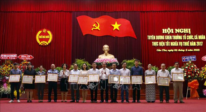Trong ảnh: Trao Bằng khen của Bộ Tài chính cho các tổ chức, cá nhân thực hiện tốt nghĩa vụ thuế. Ảnh: Thanh Liêm - TTXVN