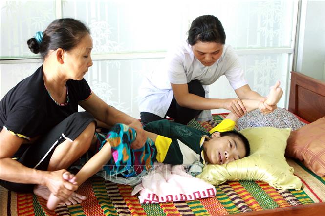 Trong ảnh: Nhân viên y tế tập phục hồi chức năng cho nạn nhân chất độc da cam/dioxin tại cơ sở nuôi dưỡng ở huyện Hòa Vang, thành phố Đà Nẵng. Ảnh: Dương Ngọc – TTXVN