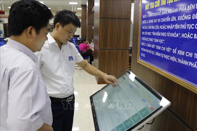 Trong ảnh: Lãnh đạo Trung tâm Phục vụ Hành chính công tỉnh Yên Bái hướng dẫn giao dịch hồ sơ trực tuyến. Ảnh: Việt Dũng - TTXVN
