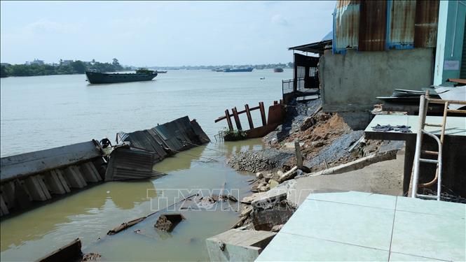 Trong ảnh: Bờ kè bị sập khiến chợ Tân Hạnh và nhiều nhà dân sạt lở, nguy cơ trôi sông. Ảnh: Công Phong - TTXVN
