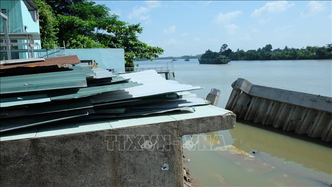 Trong ảnh: Bờ kè bị nước cuốn ra xa nên nền chợ Tân Hạnh có thể bị sập bất cứ lúc nào. Ảnh: Công Phong - TTXVN