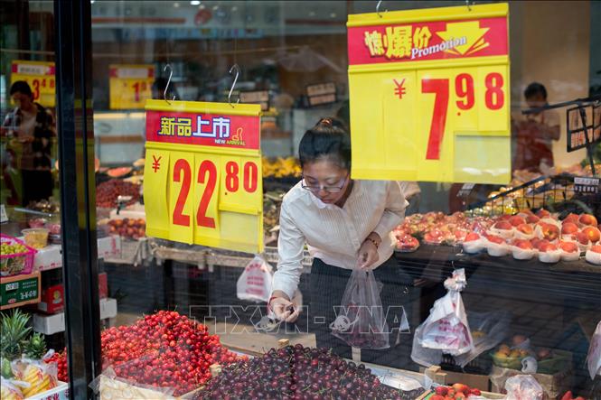 Trong ảnh: Người dân mua thực phẩm tại cửa hàng ở Bắc Kinh, Trung Quốc ngày 17/5. Ảnh: AFP/ TTXVN