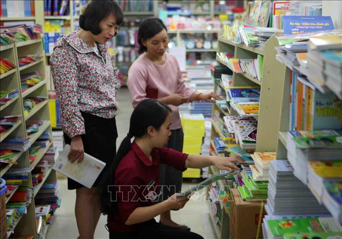 Trong ảnh: Phụ huynh chọn mua sách giáo khoa tại cửa hàng sách giáo dục 187 Giảng Võ (Hà Nội). Ảnh: Thanh Tùng-TTXVN
