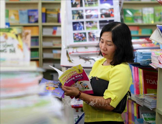 Trong ảnh: Phụ huynh chọn mua sách giáo khoa tại cửa hàng sách giáo dục 187 Giảng Võ (Hà Nội). Ảnh: Thanh Tùng-TTXVN