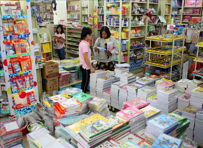 Trong ảnh: Phụ huynh chọn mua sách giáo khoa, đồ dùng học tập cho con em tại cửa hàng sách giáo dục 187 Giảng Võ (Hà Nội). Ảnh: Thanh Tùng-TTXVN