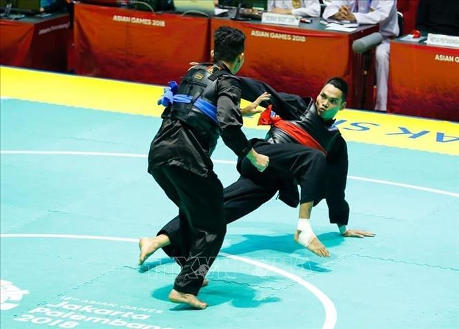 Photo: Pencak Silat athlete Tran Dinh Nam (red belt) competes with athlete Khalid Mohd Rauzi (blue belt). VNA Photo: Trọng Tuệ - Phúc Hưng 