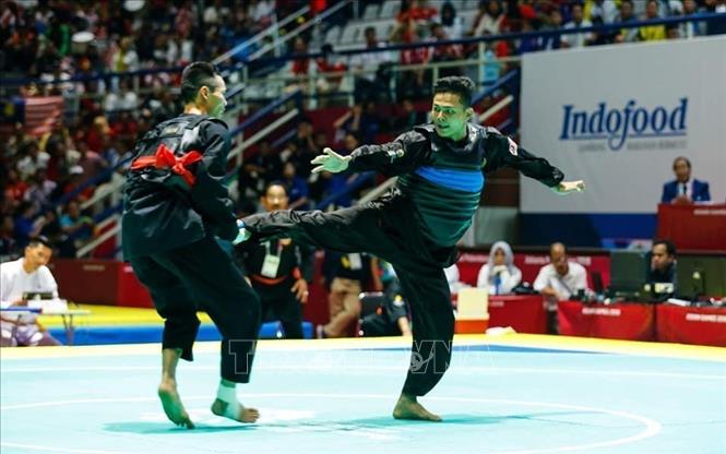 Photo: Pencak Silat athlete Tran Dinh Nam (red belt) competes with athlete Khalid Mohd Rauzi (blue belt). VNA Photo: Trọng Tuệ - Phúc Hưng 