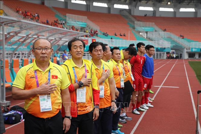 Photo: Vietnamese football team’s coaches sing the national anthem ahead of the match. VNA Photo: Hoàng Linh