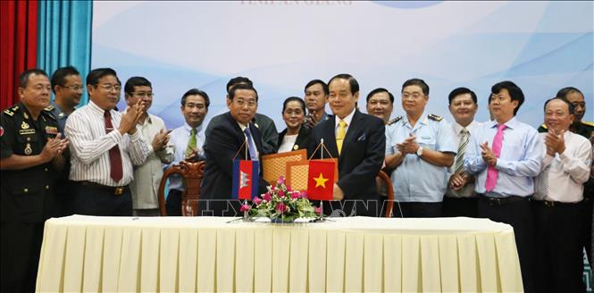 Trong ảnh: Chủ tịch UBND tỉnh An Giang Vương Bình Thạnh (bên phải) và ông Ouch Phea Tỉnh trưởng, Chủ tịch Đảng Nhân dân Campuchia tỉnh Takeo ký thỏa thuận hợp tác giữa 2 tỉnh. Ảnh: Công Mạo-TTXVN