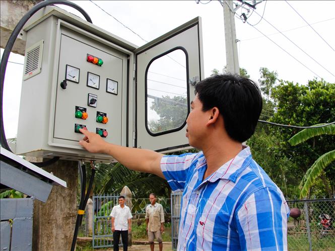 Trong ảnh: Cán bộ Trạm thủy lợi Vị Thanh vận hành cống. Ảnh: Hồng Thái - TTXVN